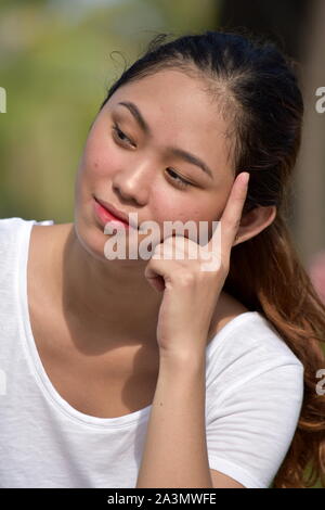 A gorgeous, thoughtful Asian woman is looking out the window while ...