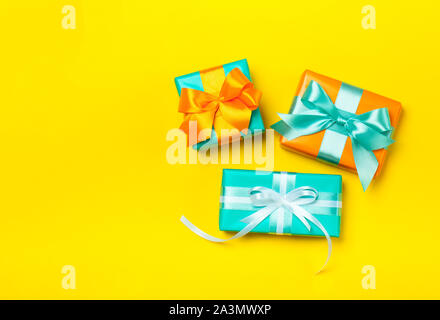 Set of attractive gifts on the yellow background. Trendy orange and green colors. Merry Christmas, St. Valentine's Day, Happy Birthday and other holidays concept. Copy space. Flat lay Stock Photo