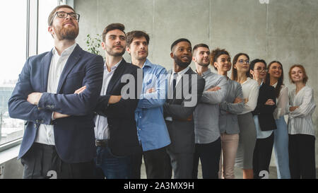 Successful business team standing in row headed with boss Stock Photo