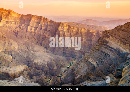 Scenic view of Wadi Ghul aka Grand Canyon of Arabia in Jebel Shams, Oman at sunset Stock Photo