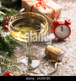 A glass of champagne sparkling wine cork clock close-up on a festive decorated table. Christmas New Year concept. Selective focus. Copy space. Square Stock Photo