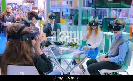 Group of teenagers using virtual reality headset at technology show Stock Photo