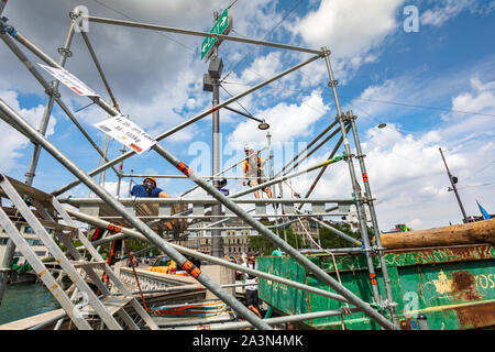 A crew of three workers mounting a scaffolding structure in Limmatquai  street in Zurich, Switzerland Stock Photo