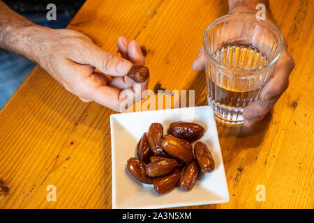Symbol picture breaking the fast in the month of Ramadan, for Muslims, water and dates after sunset, as the first meal of the day, Stock Photo