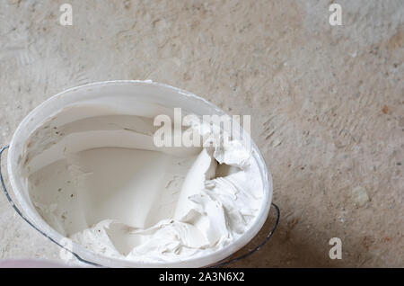 Mixed putty solution in a pail ready to be used. Construction works concept. Copy space Stock Photo