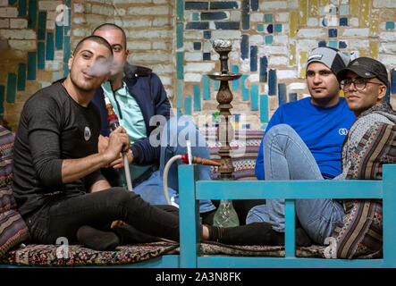 Tehran, Iran - 2019-04-05 - Men smoking hookah water pipe in restaurant. Stock Photo