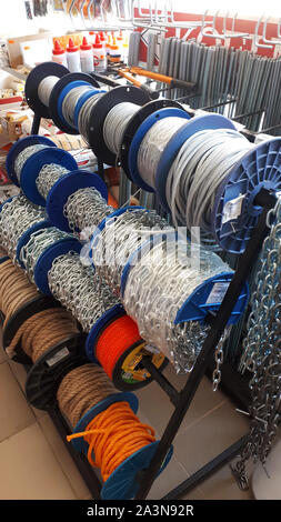 Terebovlia,Ternopil/Ukraine-August 24,2019: Industrial stainless chains and cables. The steel chain is reeled up on the big coil in a building materia Stock Photo