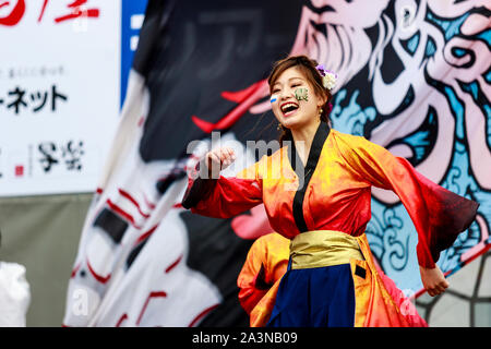 Kyusyu Gassai festival in Kumamoto, Japan. Close up of Yosakoi dancer dancing, with mouth wide open and happy expression. Wears red and yellow jacket.