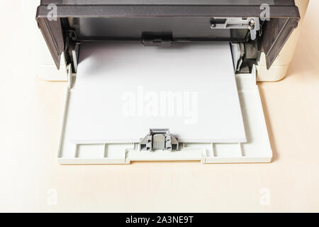 sheets of blank white paper in printer tray of multi function device on table in office Stock Photo