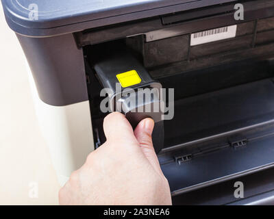 installing new toner cartridge in laser multi function device on table in office Stock Photo