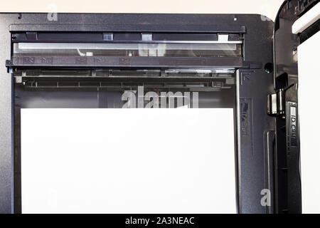 top view of sheet of paper on glass of scanner in multi function device on table in office Stock Photo