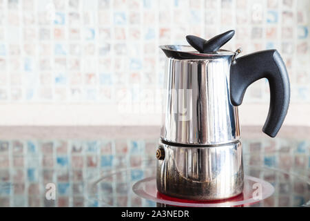 Brewing coffee with italian moka pot on ceramic electric range at home kitchen Stock Photo