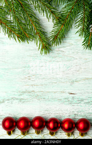 Fir spruce pine coniferous branches sparkling shiny multi-colored red balls on a brown matte wooden light background Stock Photo