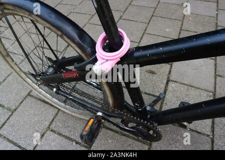 Pink bicycle lock on black bicycle Stock Photo