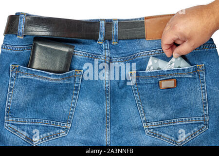 Hand pulls credit card out of jeans pocket. Stock Photo