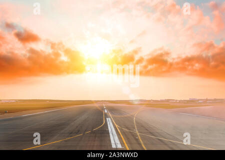 Airport empty runway in the evening sunset light, clear for airplane landing or taking off. Stock Photo