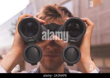 close up tourist holding binocular and searching the way, macro lens view Stock Photo