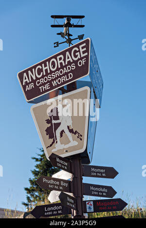 Sign showing distances to other cities at the Visit Anchorage Log Cabin Visitor Information Center at Peratrovich Park in downtown Anchorage, Alaska. Stock Photo