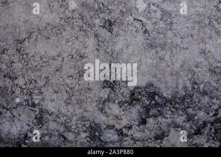 White and grey granite, limestone, or travertine surface with random black organic natural deep bumpy scratch pattern on surface. Stock Photo