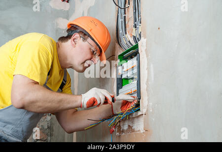 The electrician is installing the fuses in the switch box. Stock Photo