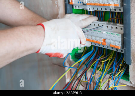 A electrician is installing the fuses in the switch box. Stock Photo