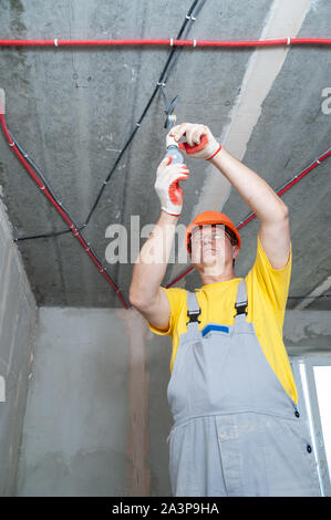 The electrician is setting a light bulb for temporary lighting. Stock Photo