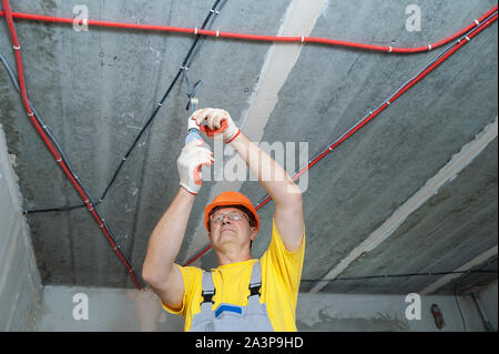 The electrician is setting a light bulb for temporary lighting. Stock Photo