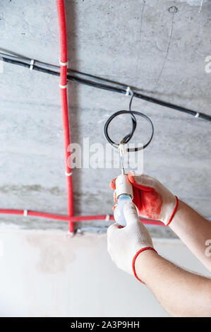 An electrician is setting a light bulb for temporary lighting. Stock Photo