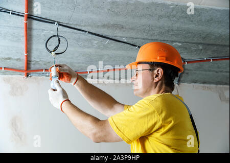 The electrician is setting a light bulb for temporary lighting. Stock Photo