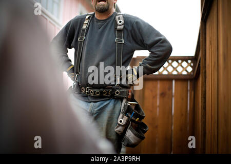 Construction worker wearing a tool belt. Stock Photo