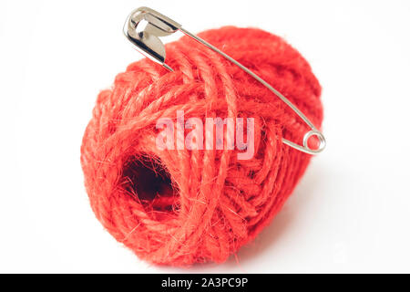 Picture of safety pin and red yarn. Isolated on the white background. Stock Photo