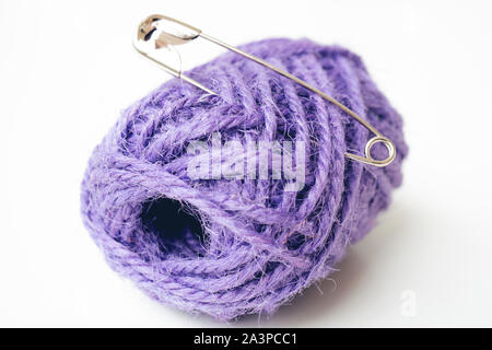 Picture of safety pin and purple yarn. Isolated on the white background. Stock Photo
