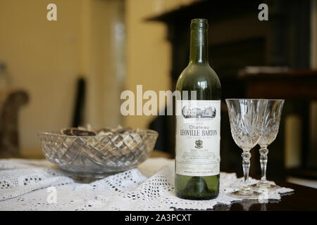 Red Wine Bottle and Two Crystal Glasses on Coffee Table Stock Photo