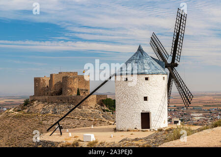 landscape in the spanish municipality of Consuegra with an old windmill and the castle of la Muela in the background on a summer day with cloudy sky Stock Photo