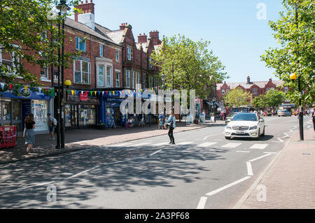 Car waiting whilst a young lady walks across the road on a Zebra Crossing in Lytham Lancashire England UK Stock Photo