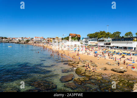 View of the crowded pretty little beach named Praia da Duquesa along the beach promenade between the towns of Estoril and Cascais, nearby Lisbon, Port Stock Photo