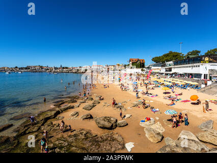 View of the crowded pretty little beach named Praia da Duquesa along the beach promenade between the towns of Estoril and Cascais, nearby Lisbon, Port Stock Photo