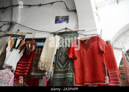Locally made textiles on display on a wall in the Souk el Trouk district of the market (souq) in the Medina (old city) of Tunis, Tunisia. Stock Photo