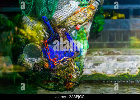 bag full of plastic coming out of the water, plastic pollution, environment awareness Stock Photo