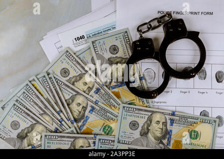 Tax form financial with handcuffs and fingerprint record criminal investigation currency US dollar banknotes Stock Photo