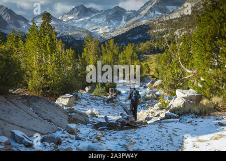 woman hiking in the snow covered trail along Little Lakes Valley in the Eastern Sierra Nevada Mountains. California USA Stock Photo