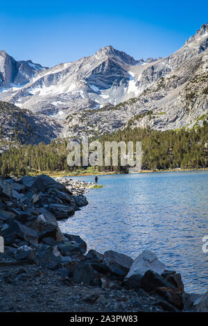 Fisherman fishing at Long Lake in Little Lakes Valley Eastern Sierra Nevada Mountains. California ;USA Stock Photo