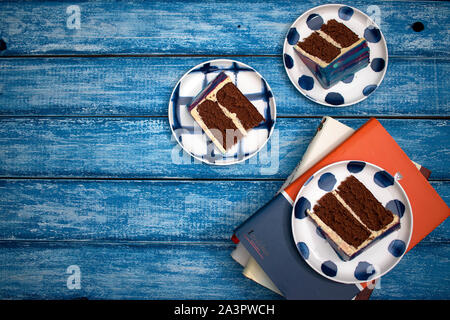 Mirror glazed cake slices on a blue wooden table Stock Photo