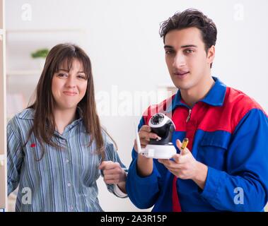 The client getting securty camera installed at home by contractor Stock Photo