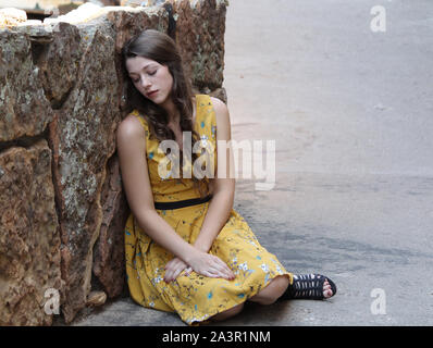 Girl resting against the wall in Estes Park, Colorado Stock Photo