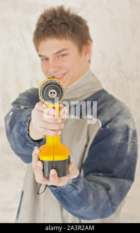 Young smiling builder in the construction making something Stock Photo