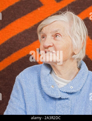 Old lonely woman staying alone at home Stock Photo
