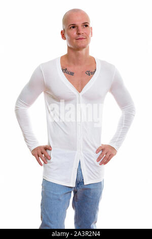 Studio shot of young handsome bald man standing and posing while Stock Photo