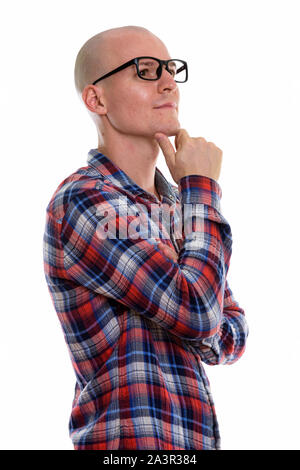 Studio shot of young handsome bald man wearing eyeglasses while Stock Photo