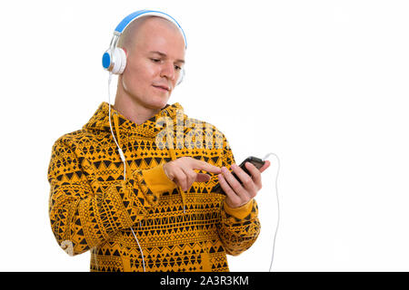 Bald man using phone while wearing headphones Stock Photo